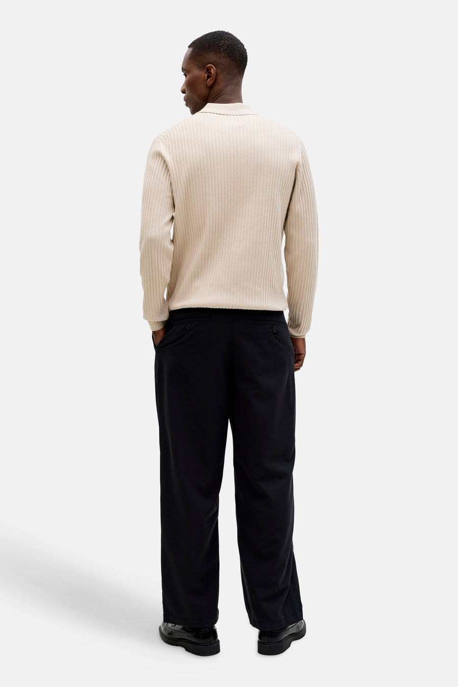 Pull beige côtelé avec col de PREMIUM by JACK & JONES, vu de dos avec pantalon noir et chaussures.