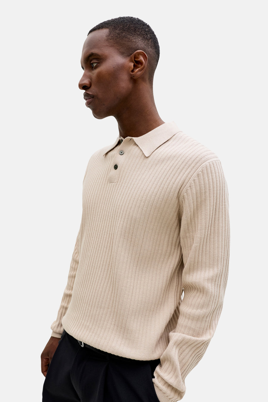 Pull beige côtelé à col polo et deux boutons de PREMIUM by JACK & JONES, porté par un homme de profil.