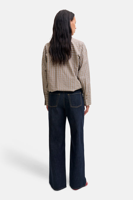 Donkere blauwe wijde jeans van JJXX, achterzijde met rechte pijpen en klassieke zakken, gedragen met geruit overhemd