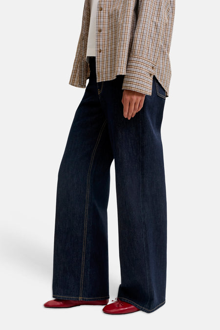 Donkere blauwe wijde jeans van denim van JJXX, met gele naden en rode schoenen, zijprofiel weergave
