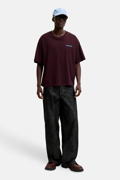 Paarse korte mouwen t-shirt van ORIGINALS BY JACK & JONES, met klein logo op borst, gedragen in lifestyle look met donkere jeans en bruine schoenen