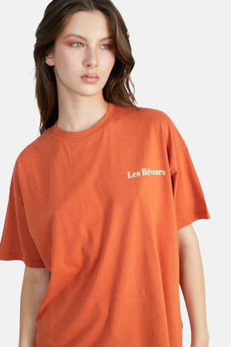 T-shirt orange à manches courtes de 24 couleurs, avec un texte en petites lettres sur la poitrine.