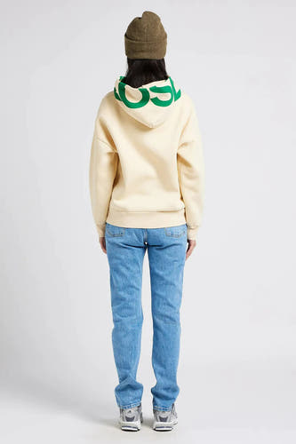 Lichtblauwe rechte jeans van Levi's, gezien van achteren, gecombineerd met een crèmekleurige hoodie en een groene beanie.
