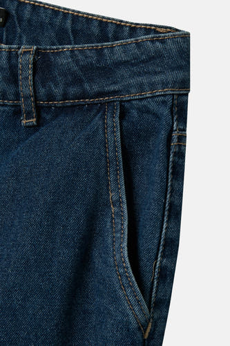 Jean bleu marine, large de LMTD, avec avec texture denim texture et une poche visible sur le côté.