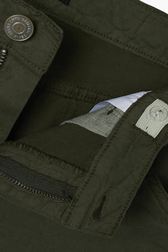 Pantalon de travail vert LMTD, avec une fermeture visible desementrits, un détail de bouton et une ceinture ajustable à l'intérieur.