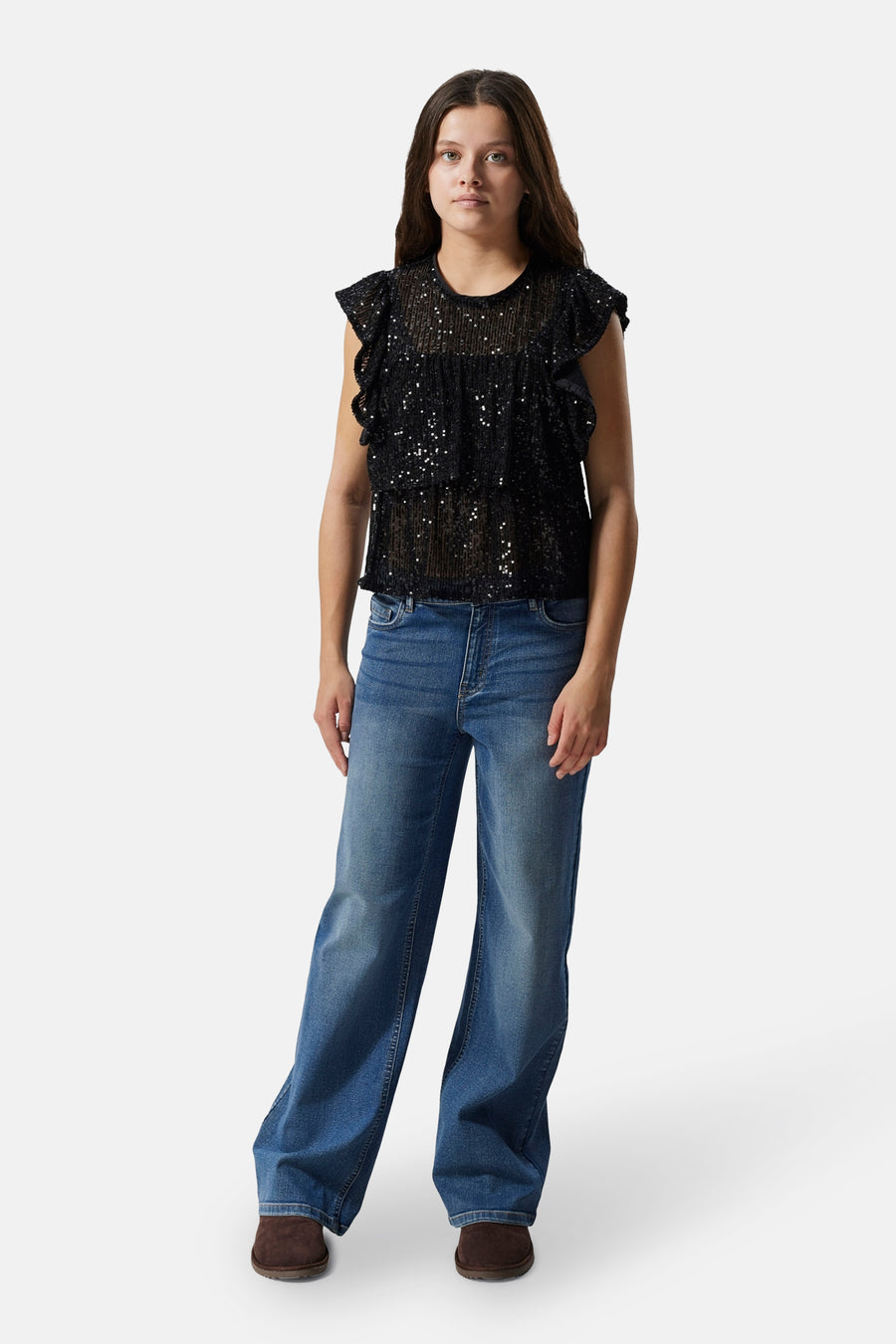 Donkerblauwe denim wide jeans van LMTD, gedragen met een zwarte paillettentop en bruine schoenen.
