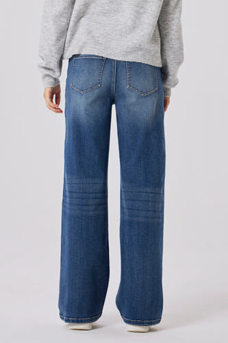 Jean en denim bleu marine large de LMTD, avec des jambes larges et des poches arrière, associé à une chemise grise.