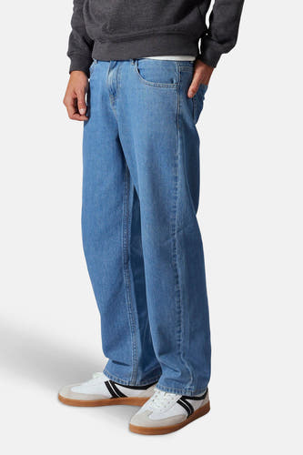 Jean droit en denim bleu clair de LMTD, avec une coupe décontractée et des baskets blanches à rayures noires.
