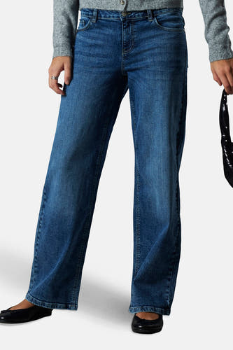 Jean droit mi-bleu denim de LMTD, porté avec un cardigan gris, une chemise blanche et des ballerines noires.