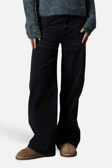 Jean délavé noir de LMTD, associé à une chemise bleu-gris et des chaussures marron.