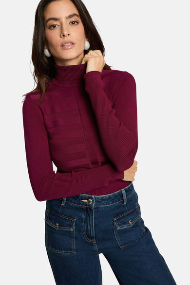 Pull-over marron avec col montant de Morgan De Toi, à rayures horizontales et associé à des jeans à poches et des bottines rouges.