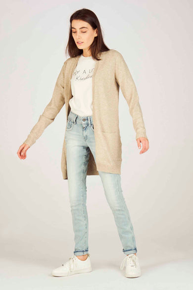 Veste beige de VILA avec des manches longues, associée à un t-shirt blanc et à des jeans légers.
