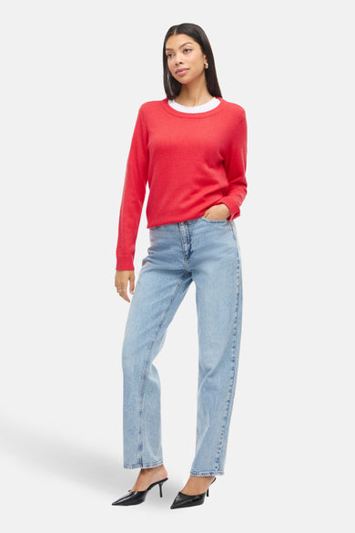 Rode trui met ronde hals van VILA®, gedragen met een wit T-shirt en blauwe jeans, en zwarte schoenen.