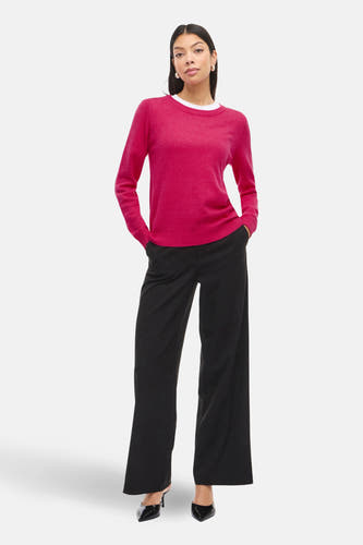 Roze trui met ronde hals van VILA®, gecombineerd met een wit shirt en zwarte pantalon met wijde pijpen.