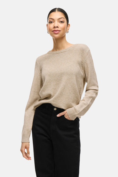 Pull beige à col rond de VILA, porté avec un pantalon noir et des boucles d'oreilles en argent.