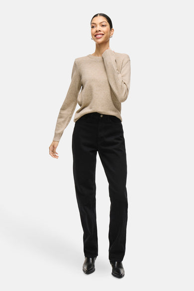 Pull beige à col rond de VILA, porté avec un pantalon noir et des chaussures noires.