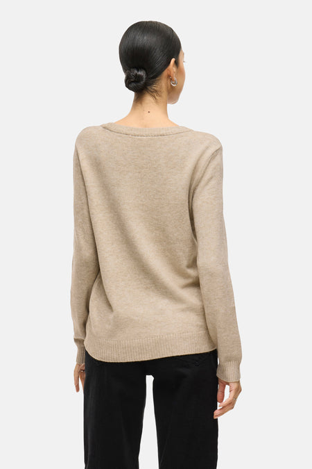 Pull beige à col rond de VILA, vu de dos, avec manches longues et combiné avec un pantalon noir.