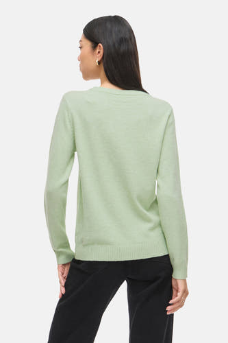 T-shirt vert de ronde col VILA®, vu vu de derrière, porté avec un pantalon noir et des boucles d'oreilles dorées.