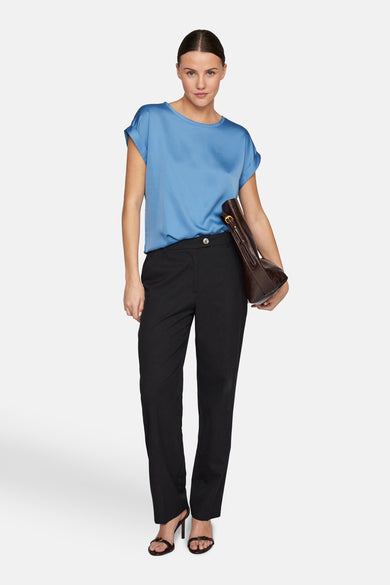 T-shirt bleu à manches courtes de VILA, avec un pantalon noir et des baskets marrons.