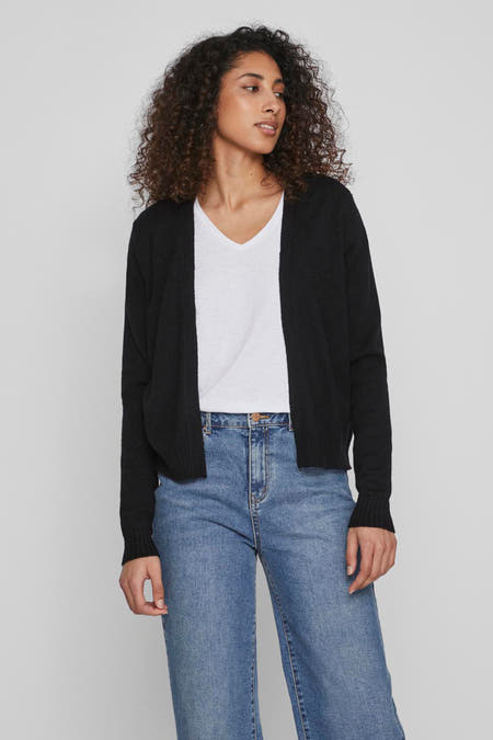 Cardigan noir de VILA, associé à un T-shirt blanc et un pantalon en denim bleu.