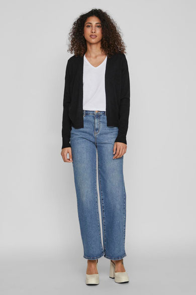 Zwarte cardigan van VILA, gestyled met een wit T-shirt en blauwe denim broek.
