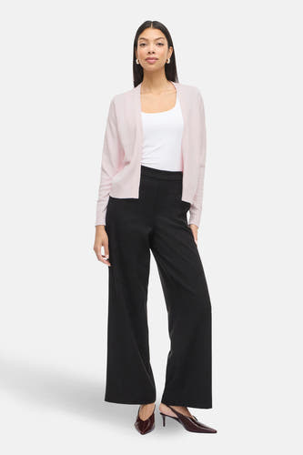 Roze cardigan van VILA®, gedragen over een wit hemdje en zwarte, wijde broek met elegante hakken.