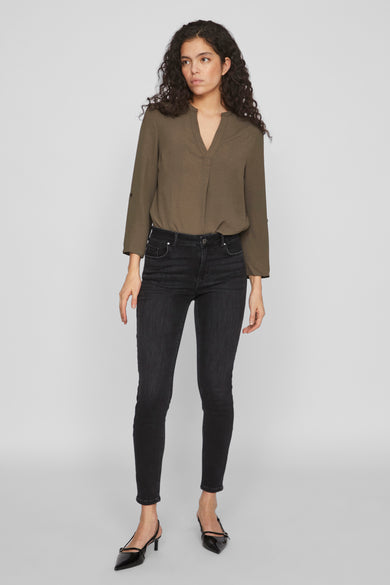 Jean skinny noir de Vila, combiné avec un blouse olivâtre et des talons noirs.