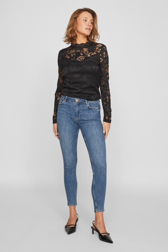 Jean skinny bleu clair de Vila, combiné avec un haut en dentelle noir et des talons noirs à sangle.