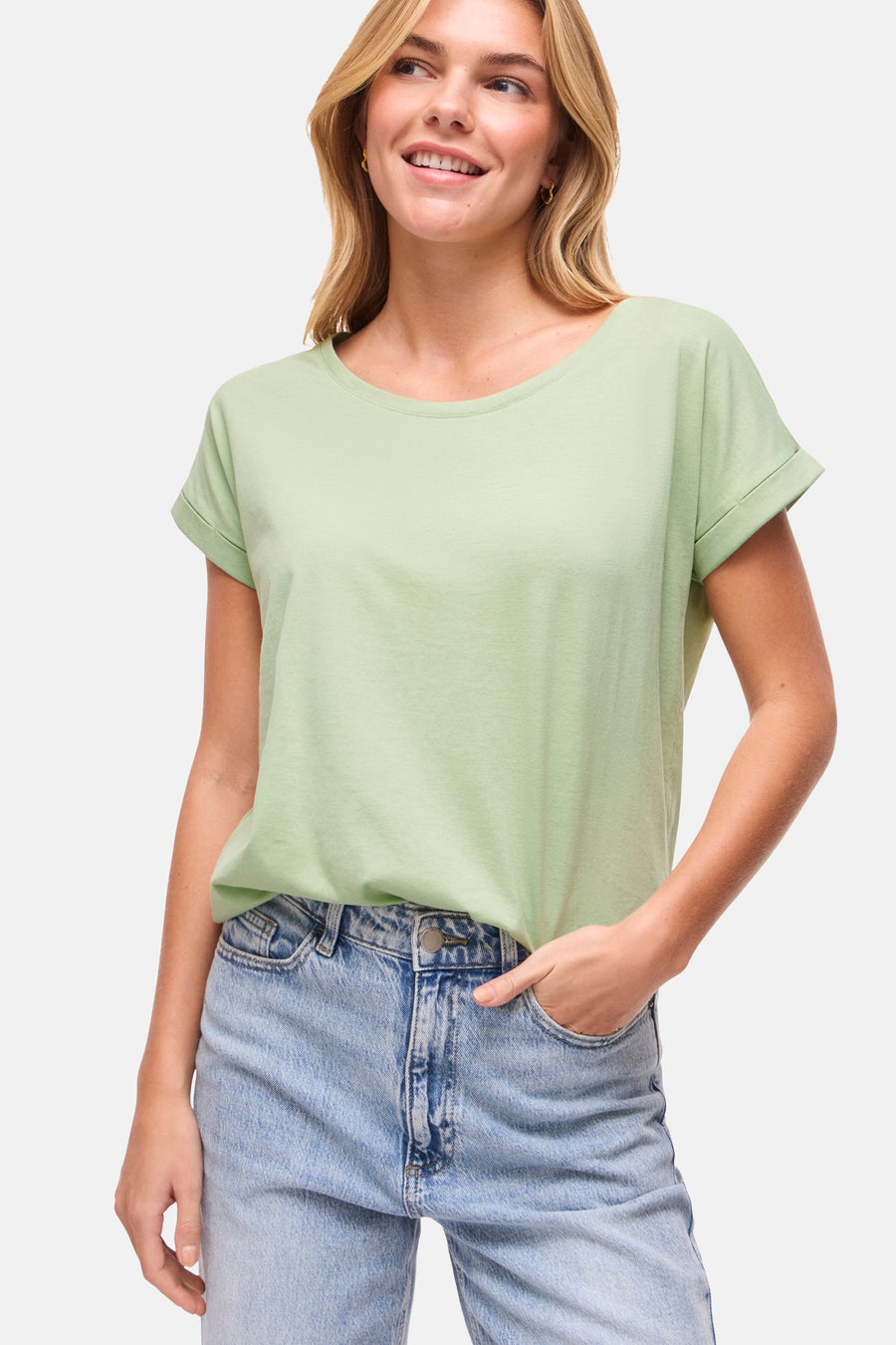 T-shirt vert à manches courtes de VILA®, avec manches retroussées et porté avec un jean bleu.
