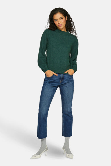 Veste verte VILA® combinée avec des jeans, des chaussettes grises et des escarpins blancs.