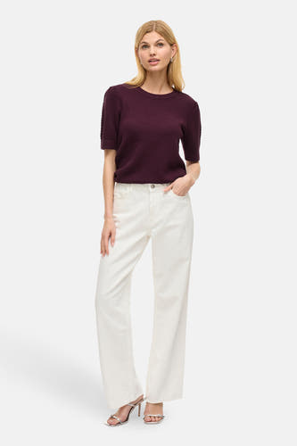 Veste VILA® de couleur noire, à manches courtes, associée à un jean blanc et des sandales argentées.