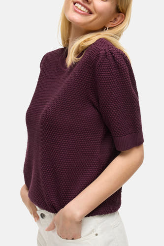 Sweat-shirt VILA® de couleur marron, avec des manches courtes et une texture fine tr tricotée, porté avec un pantalon blanc, vue arrière.