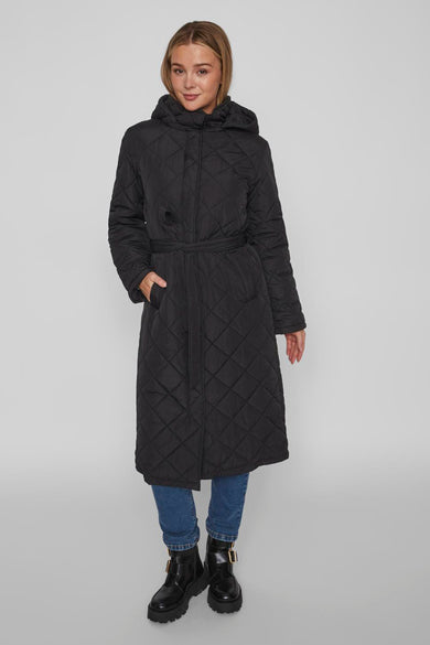 Manteau long noir de Vila avec ceinture et un motif de lunettes de soleil brodé sur le dos.
