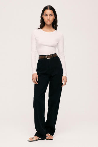 Jean droit noir en denim de VILA®, avec une ceinture marron et une chemise blanche.