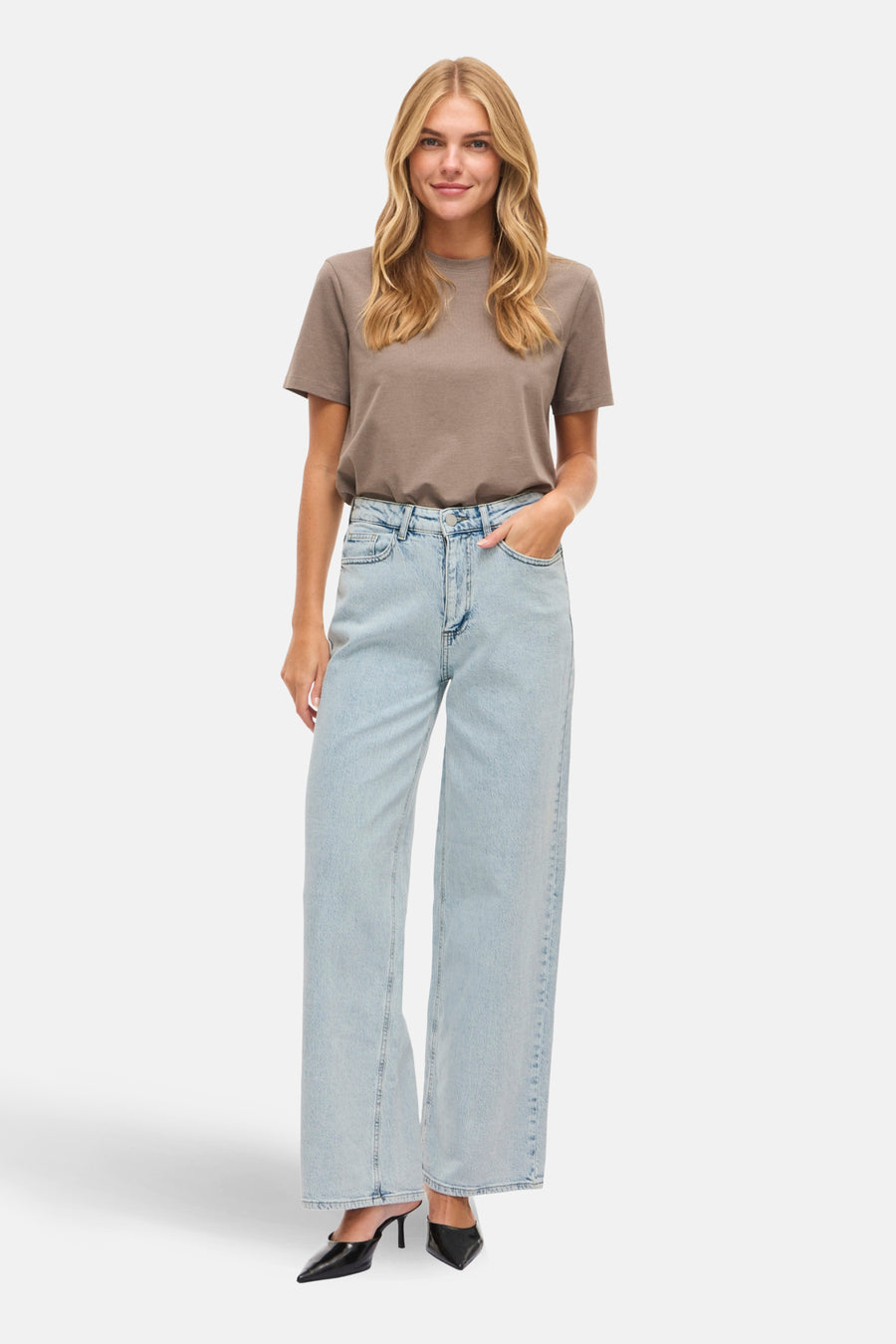 Lichtblauwe denim jeans wide van Vila, met een rechte pijp en gedragen met een bruin T-shirt.
