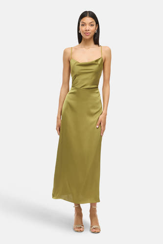 Chemise à manches courtes verte de VILA, avec une texture soyeuse et des fines bretelles, portée avec des sandales dorées.