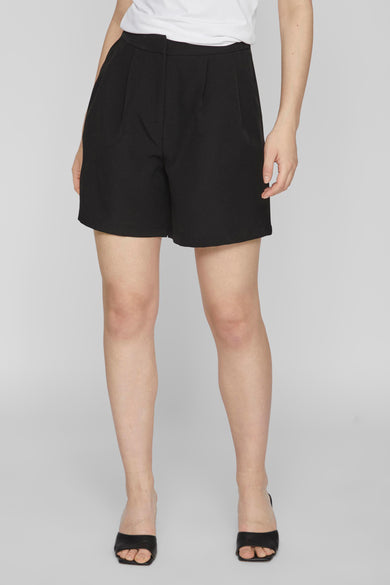 Short noir de VILA, associé à une chemise blanche et des baskets noires.