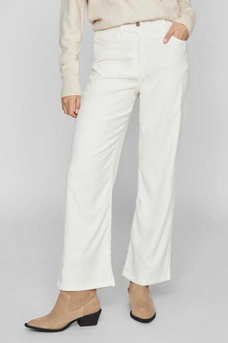 Ecru broek van VILA®, met wijde pijpen en gecombineerd met beige trui en suède laarsjes.
