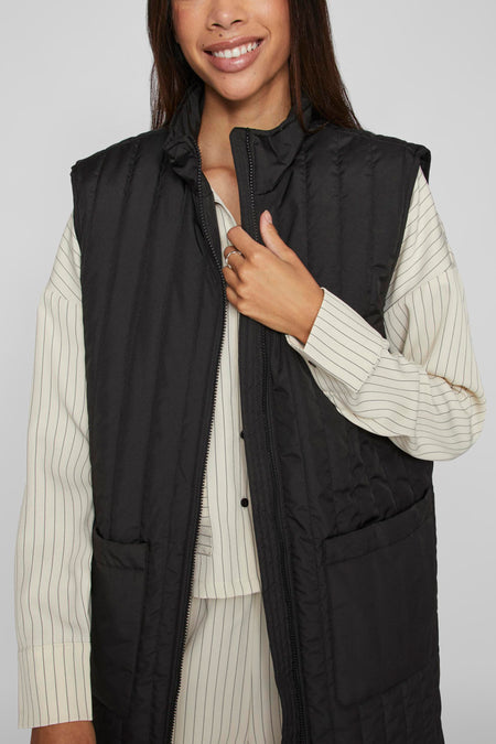 Gilet chauffant noir de VILA®, avec un design tricoté, une fermeture éclair et des poches.