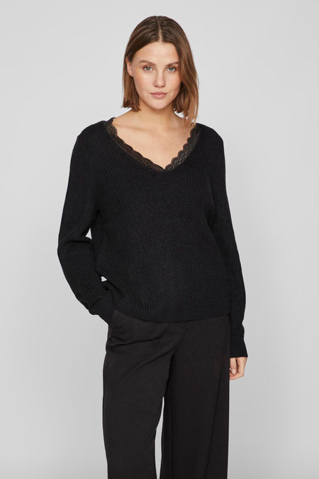 Pull noir à col V de VILA®, terminé par un biais au col, associé à une pantalon noir large et fluide.