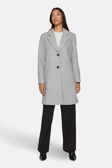 Manteau long gris de VILA®, avec des boutons noirs, associé à une chemise blanche et un pantalon noir.