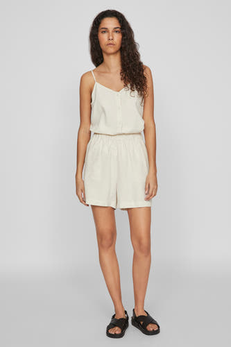 Ecru short van VILA, met elastische tailleband en gedragen met zwarte sandalen.