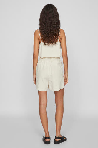 Ecru short van VILA, gezien van achteren, gecombineerd met een top en zwarte sandalen.