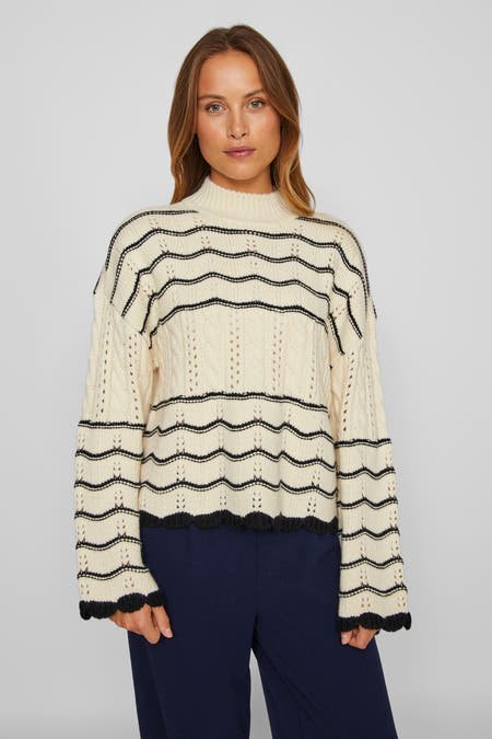 Blouse à col montant beige de Vila, avec des rayures noires ondulées et un motif côtelé.