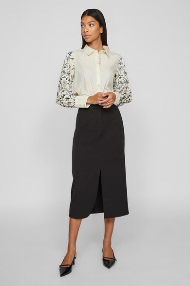 Robe longue noire de VILA, avec une fente à l'avant, combinée à une blouse brodée.