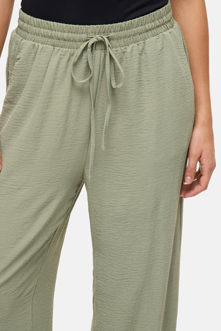 Jean vert de VILA® avec une ceinture élastique et une corde, dans une texture légère et froissée.