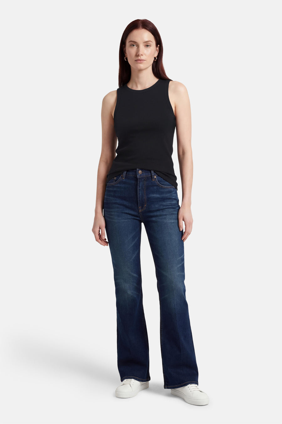 Haut noire sans manches de VILA®, combinée avec un jean foncé et des baskets blanches.