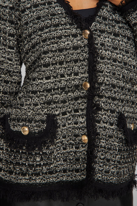Gilet noir de VILA® avec des boutons dorés et des détails froncés, associé à une jupe noire.