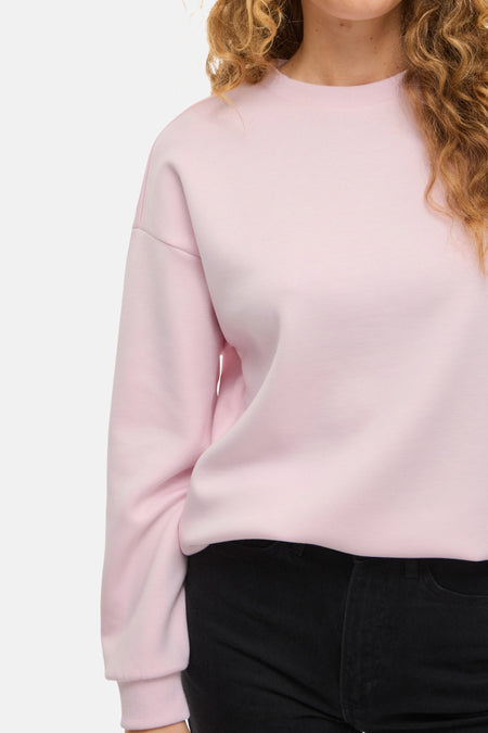 Roze sweater met zwarte broek.
