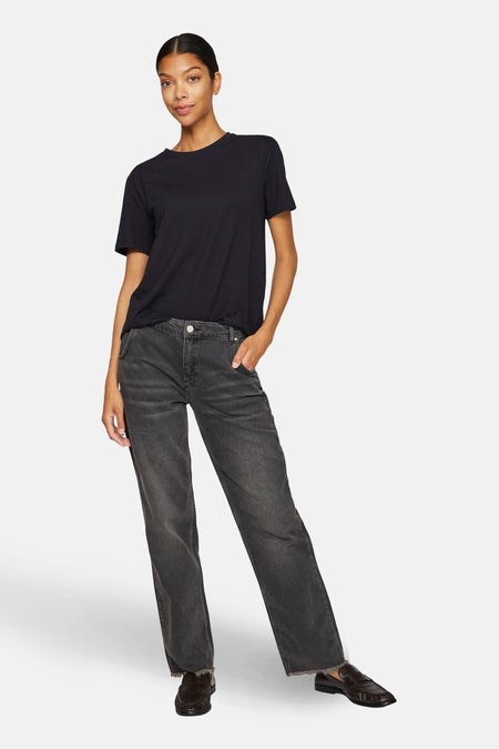 Zwart T-shirt met korte mouwen van VILA®, gedragen met grijze jeans en bruine loafers.